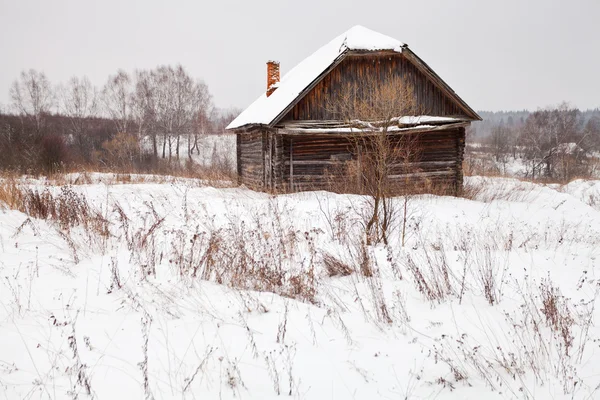 Casa abandonada en pueblo cubierto de nieve —  Fotos de Stock