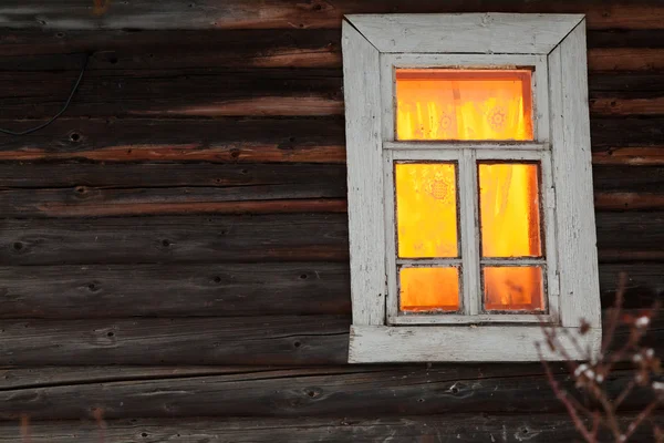 Verlichting venster van landelijke blokhuis — Stockfoto