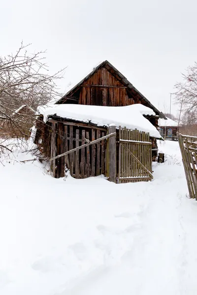Abandonado en un pueblo cubierto de nieve — Foto de Stock