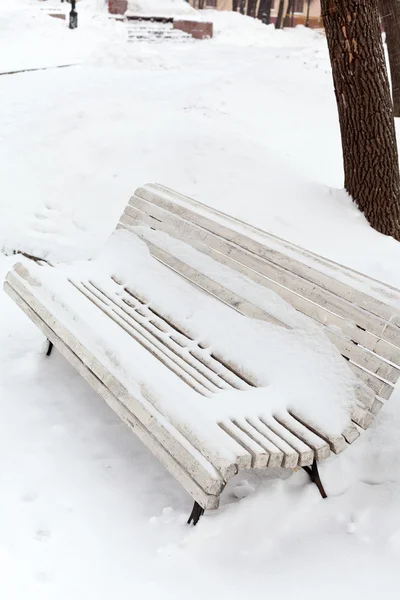 Bílý zasněžený dřevěná lavička — Stock fotografie