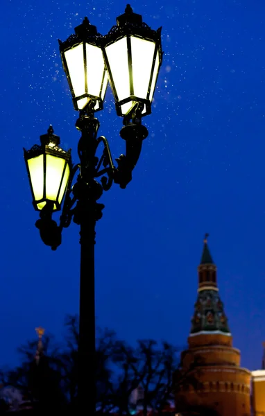 Открытый фонарь и башня Кремля в зимний снежный вечер — стоковое фото
