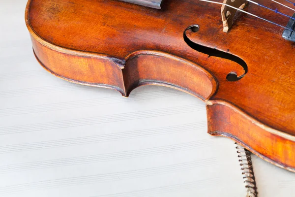Violin bout with f-hole on music book — Stock Photo, Image