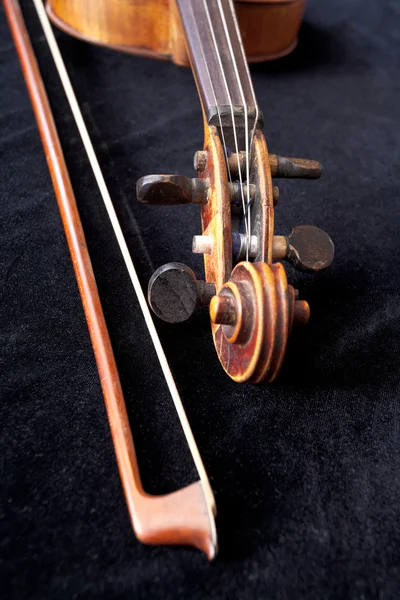 Fiddle scroll and bow on black velvet — Stock Photo, Image