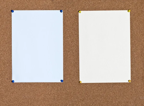 Blaue und gelbe Papierbögen auf Kork — Stockfoto