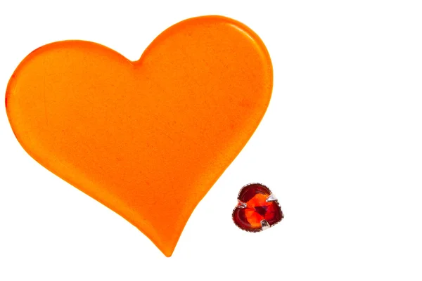 Large orange plastic heart and small red glass heart — Stock Photo, Image