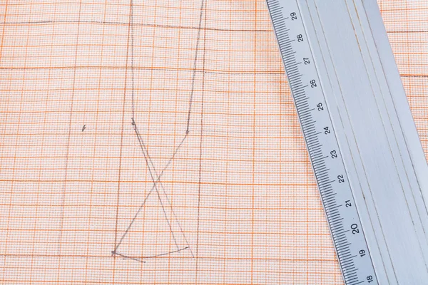 Metal ruler at graph paper — Stock Photo, Image