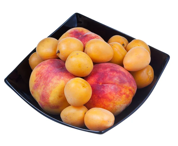 Peaches and apricots in black plate — Stock Photo, Image