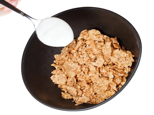 Cornflakes and spoon with yogurt — Stock Photo, Image