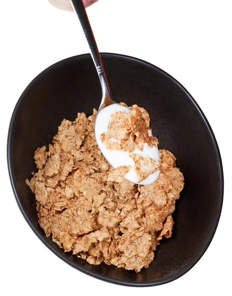 Cornflakes and spoon with yogurt — Stock Photo, Image