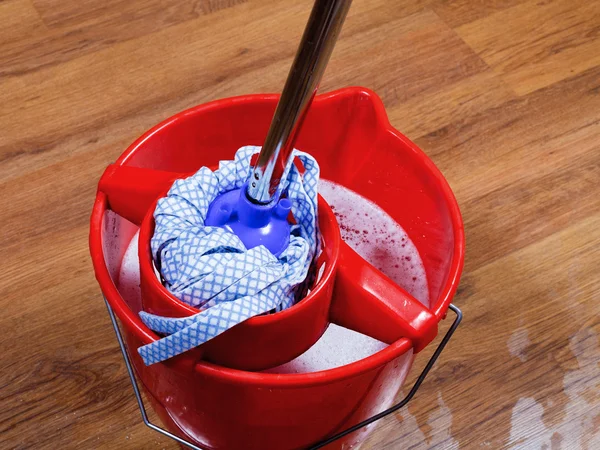 Mop in red bucket with water — Stock Photo, Image