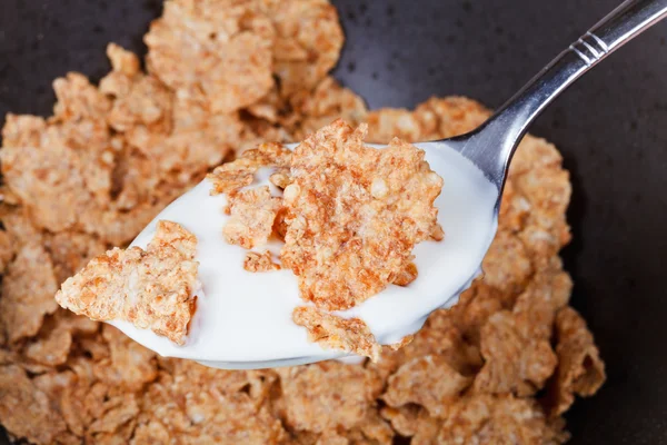 Yogurt and flakes in spoon — Stock Photo, Image