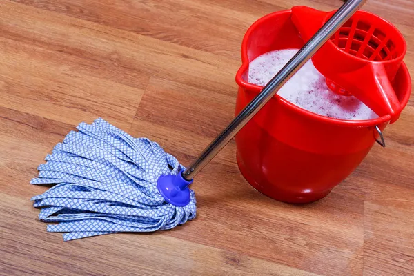 Blauwe textiel mop en rode emmer — Stockfoto