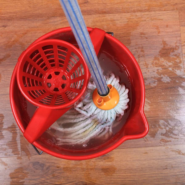 Textile mop in red bucket — Stock Photo, Image