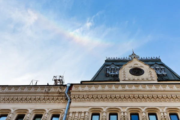 Regenboog in blauwe hemel over hoofdgebouw — Stockfoto