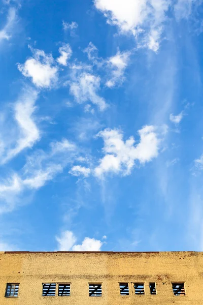 Blauer Himmel über möbliertem Gebäude — Stockfoto