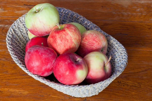 Fresh apples in straw basket — Stock Photo, Image