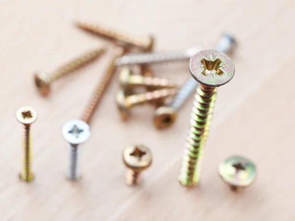 Screws wrapped in wooden floor — Stock Photo, Image