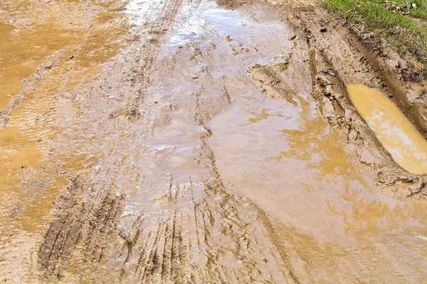 Modder en plas op onverharde weg — Stockfoto