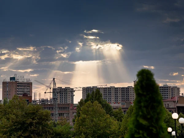 Les rayons du soleil à travers les nuages illuminent les nouveaux bâtiments — Photo