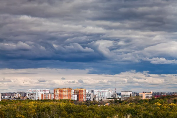 Nuvens chuvosas azuis escuras sobre a cidade no outono — Fotografia de Stock