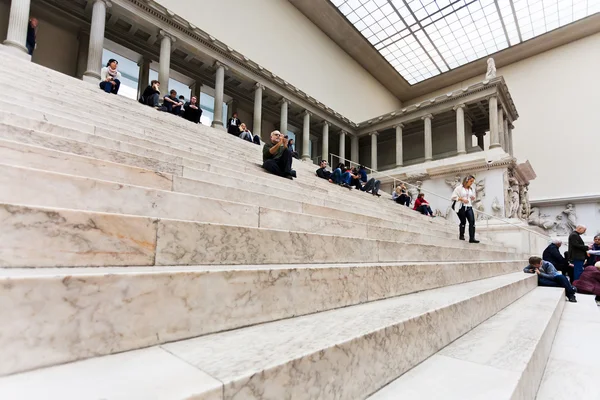 Les gens s'assoient sur les marches dans le Hall du musée de Pergame — Photo