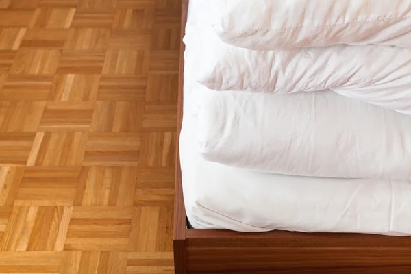 Cobertor dobrado e lençol em cama de casal — Fotografia de Stock