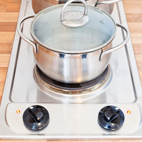 Boiling water in metal pot on hotplate — Stock Photo, Image