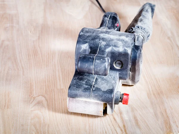 Belt sander at finished ashwood furniture board — Stock Photo, Image