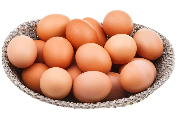 Many fresh chicken eggs in wicker basket — Stock Photo, Image