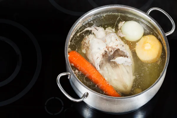 Boiling of chicken broth on cermic cooker — Stock Photo, Image