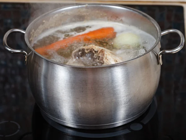 Simmering chicken soup in pot on cooker close up — Stock Photo, Image