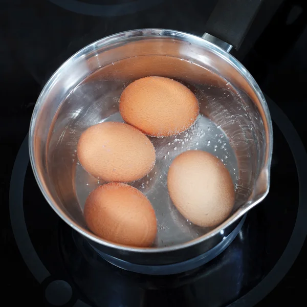 Вид зверху на киплячі курячі яйця в металевому горщику — стокове фото