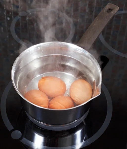 Boiling chicken eggs in metal pot — Stock Photo, Image