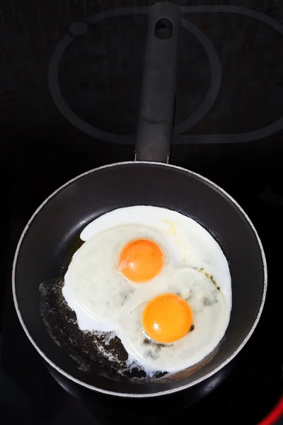 Two fried eggs in hot frying pan — Stock Photo, Image