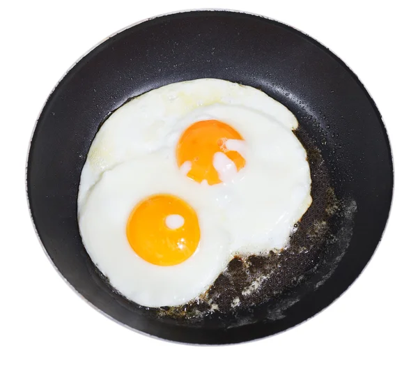 Top view of fried eggs in pan isolated on white — Stock Photo, Image