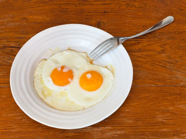Desayuno con dos huevos fritos en plato blanco — Foto de Stock