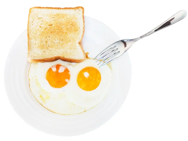 Petit déjeuner avec deux œufs frits dans une assiette blanche — Photo