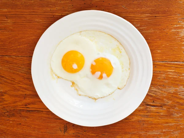 Breakfast with two fried eggs in white plate — Stock Photo, Image