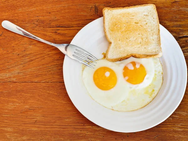 Breakfast with two fried eggs in white plate — Stock Photo, Image