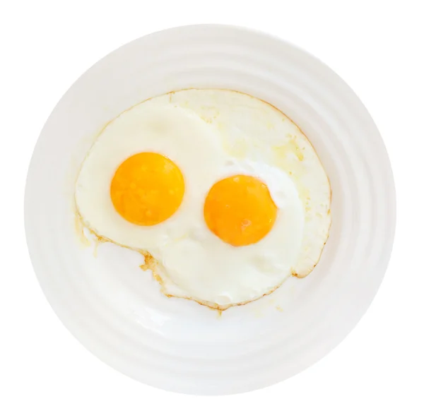 Ontbijt met twee gebakken eieren in witte plaat — Stockfoto