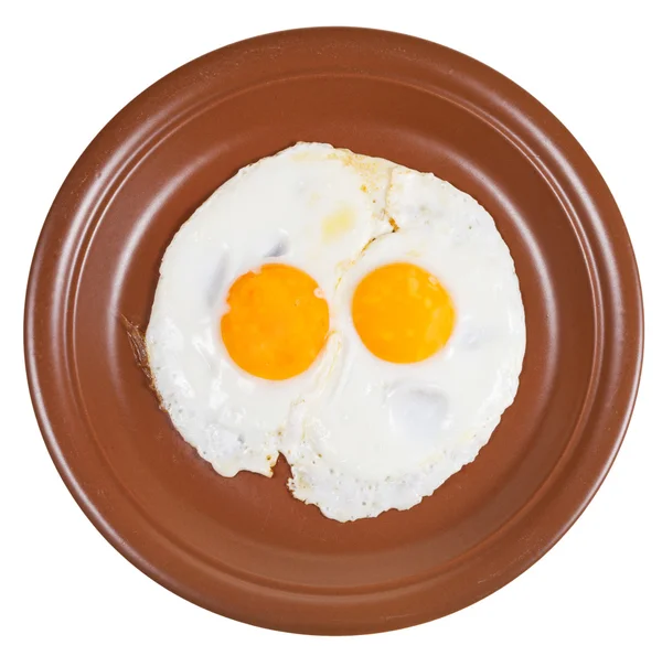 Bovenaanzicht van twee gebakken eieren op keramische bruin plaat — Stockfoto
