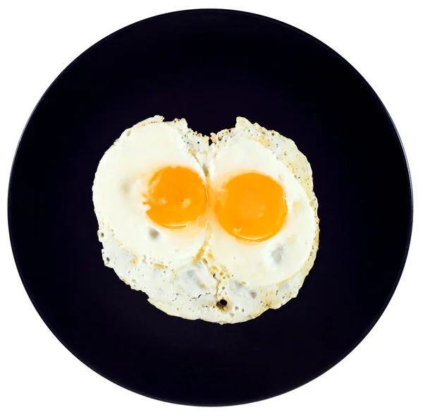 Pohled shora dvě smažená vejce na keramický černý plát — Stock fotografie