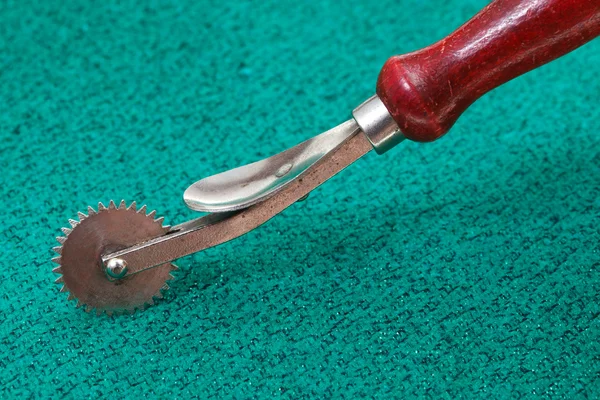 Roda de traçado de costura em têxteis verdes — Fotografia de Stock