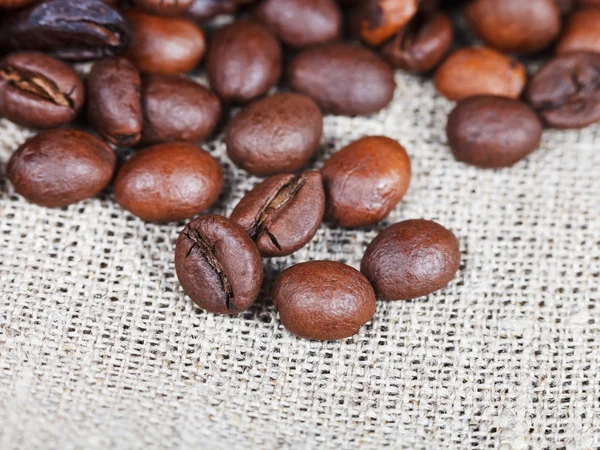 Roasted coffee beans on sackcloth — Stock Photo, Image
