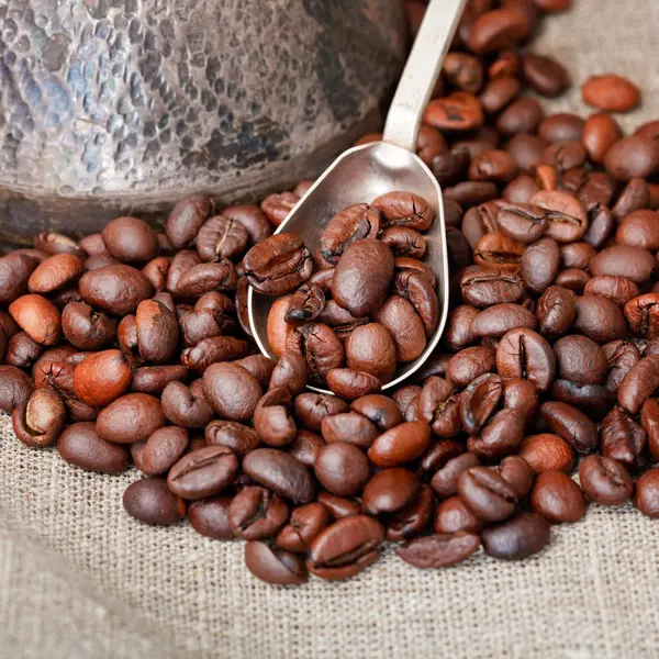 Gebrande koffiebonen en koperen pot — Stockfoto