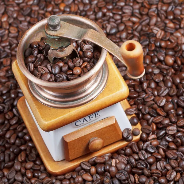 Retro manual coffee mill on roasted beans — Stock Photo, Image