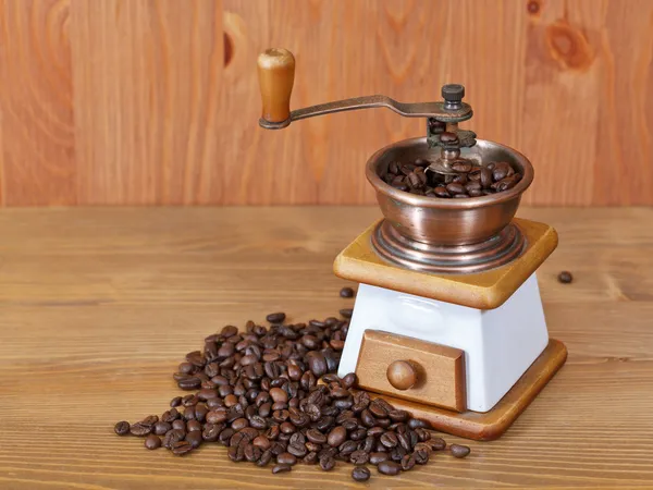 Heap of coffee and vintage manual mill — Stock Photo, Image