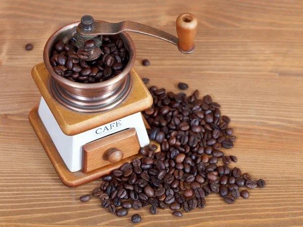 Heap of coffee and vintage manual mill — Stock Photo, Image