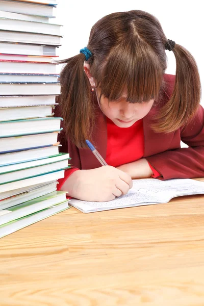 Schoolgirl, schoolwork and stack of books — Stock Photo, Image