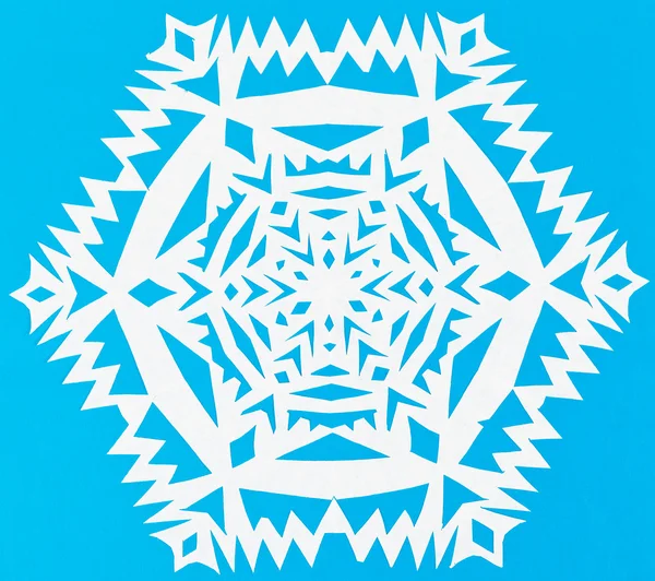 White snowflake on blue paper — Stock Photo, Image